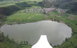 Man sieht einen See aus einem Flugzeug heraus fotografiert