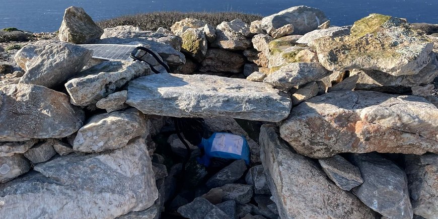 A measuring device under rocks.