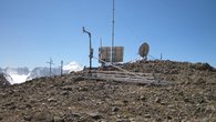 The picture shows the ROMPS on the Abramov Glacier. In the foreground is a snow measuring system. Behind it, from right to left, is the GPS antenna, solar cells and the wind mast, a rain collector and on the left a radiation sensor and a temperature measuring device.