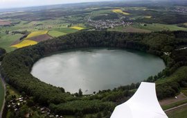 Man sieht einen kreisrunden See, der aus einem Flugzeug heraus fotografiert wurde