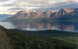 The picture shows water with mountains behind it