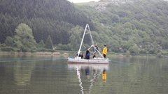 You can see a small drilling platform with three people on a lake