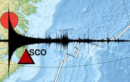 The seismological measurement as a black tremor curve lies over a map of Greenland and the adjacent Atlantic Ocean.