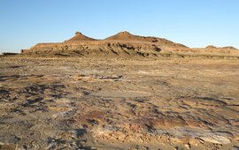 Ausgetrockneter Wüstensee auf der Arabischen Halbinsel mit Gebirgszug im Hintergrund