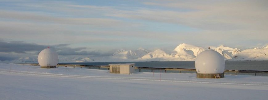 Das Foto zeigt die Satelliten-Empfangsstation Ny-Alesund (NYA) mit zwei Antennen und einer Hütte für die Empfangstechnik